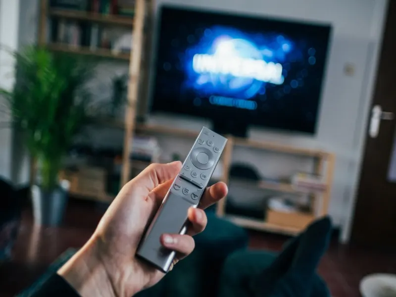 man pointing remote at samsung tv