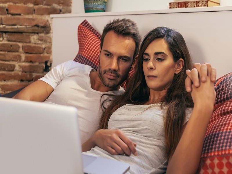 Couple in Bed Watching a Movie on a Laptop